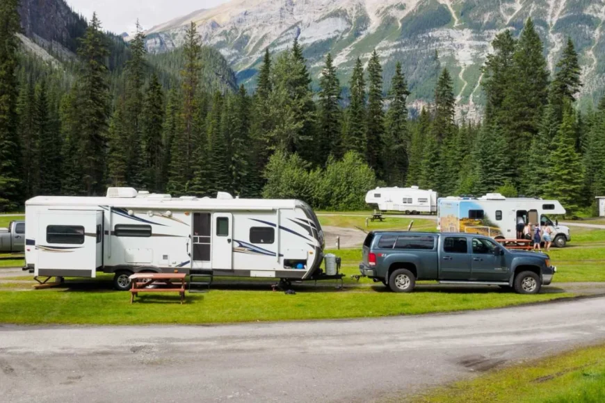 damaged rv is being towed by a black truck