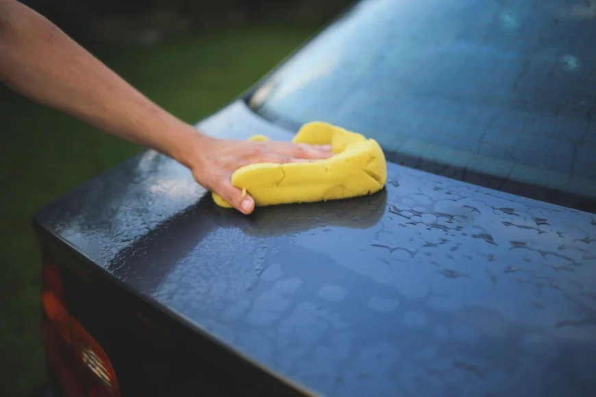 careful hand cleaning a black car